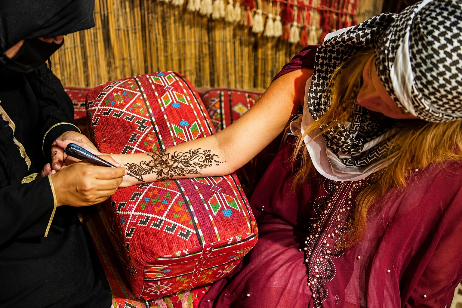 A woman enjoying complimentary henaa paint on one hand